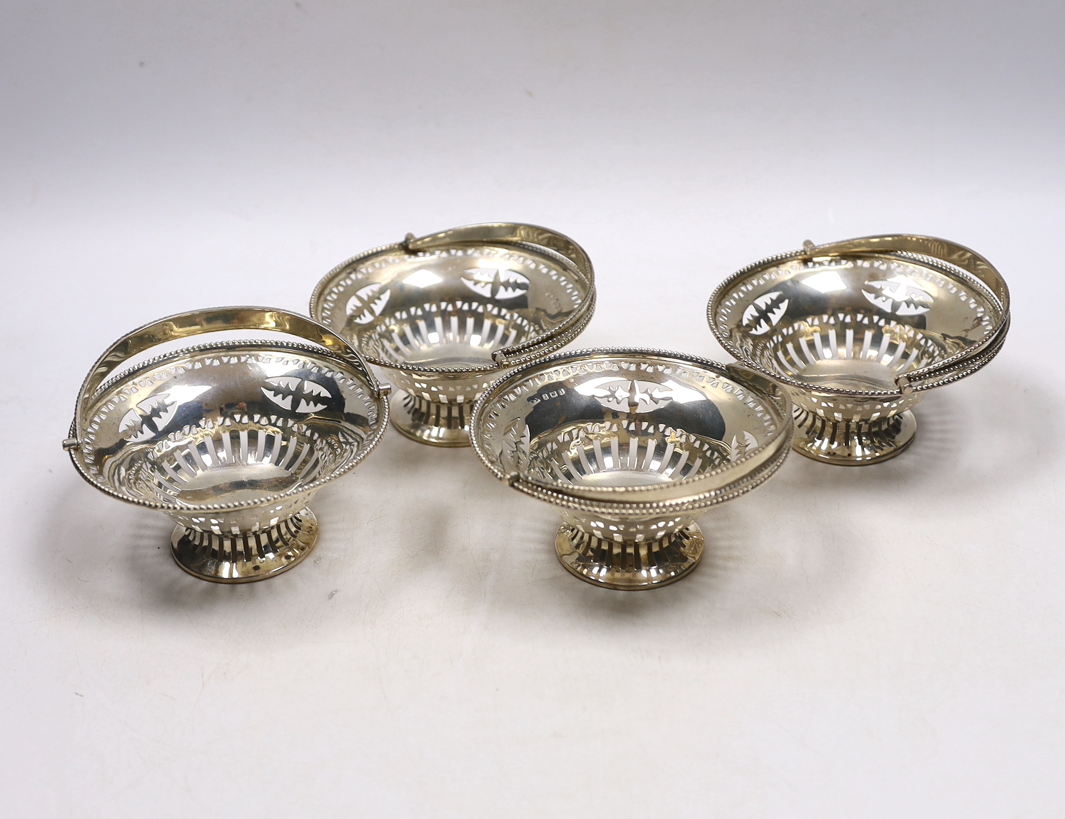 A set of four Edwardian pierced silver circular bonbon baskets, William Neale, Birmingham, 1908, 10cm.